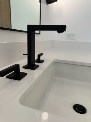 Modern bathroom faucet in black finish with a minimalist sink design.